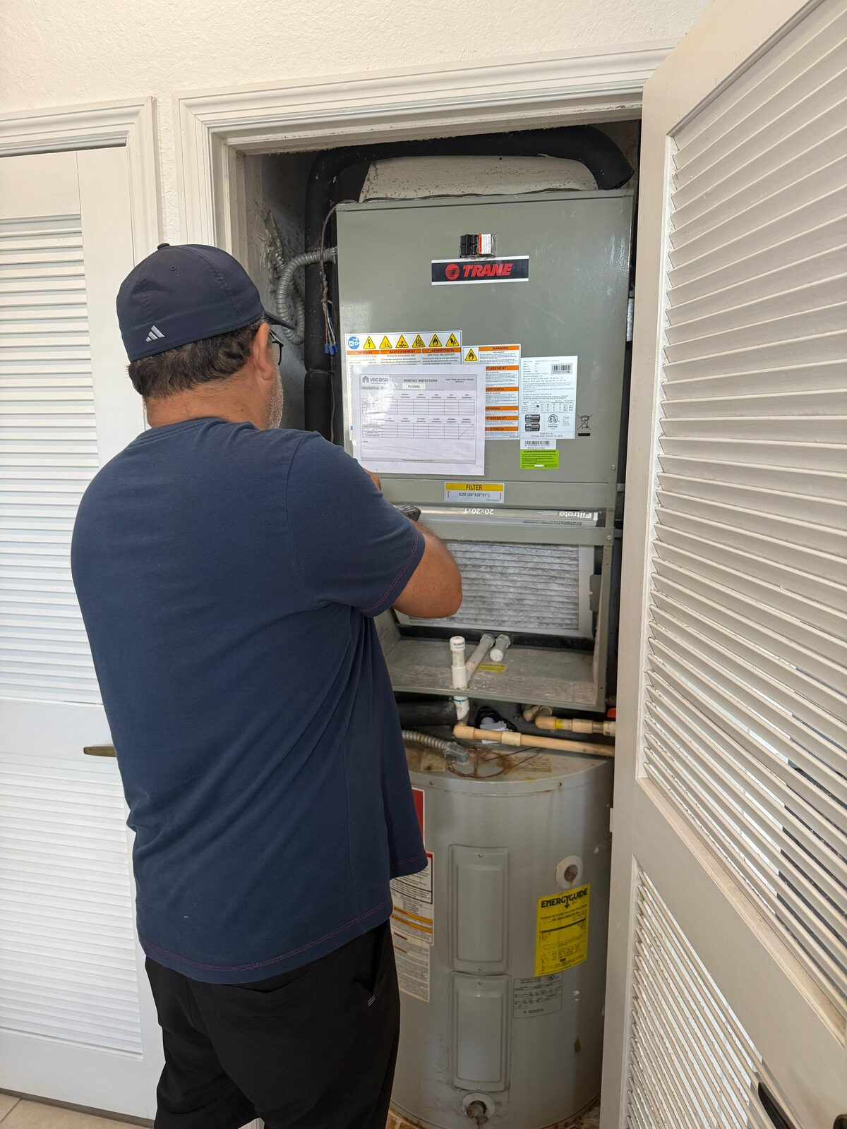Go2 Workers pro using a meter to diagnose an AC air handler during a service visit in Central Florida