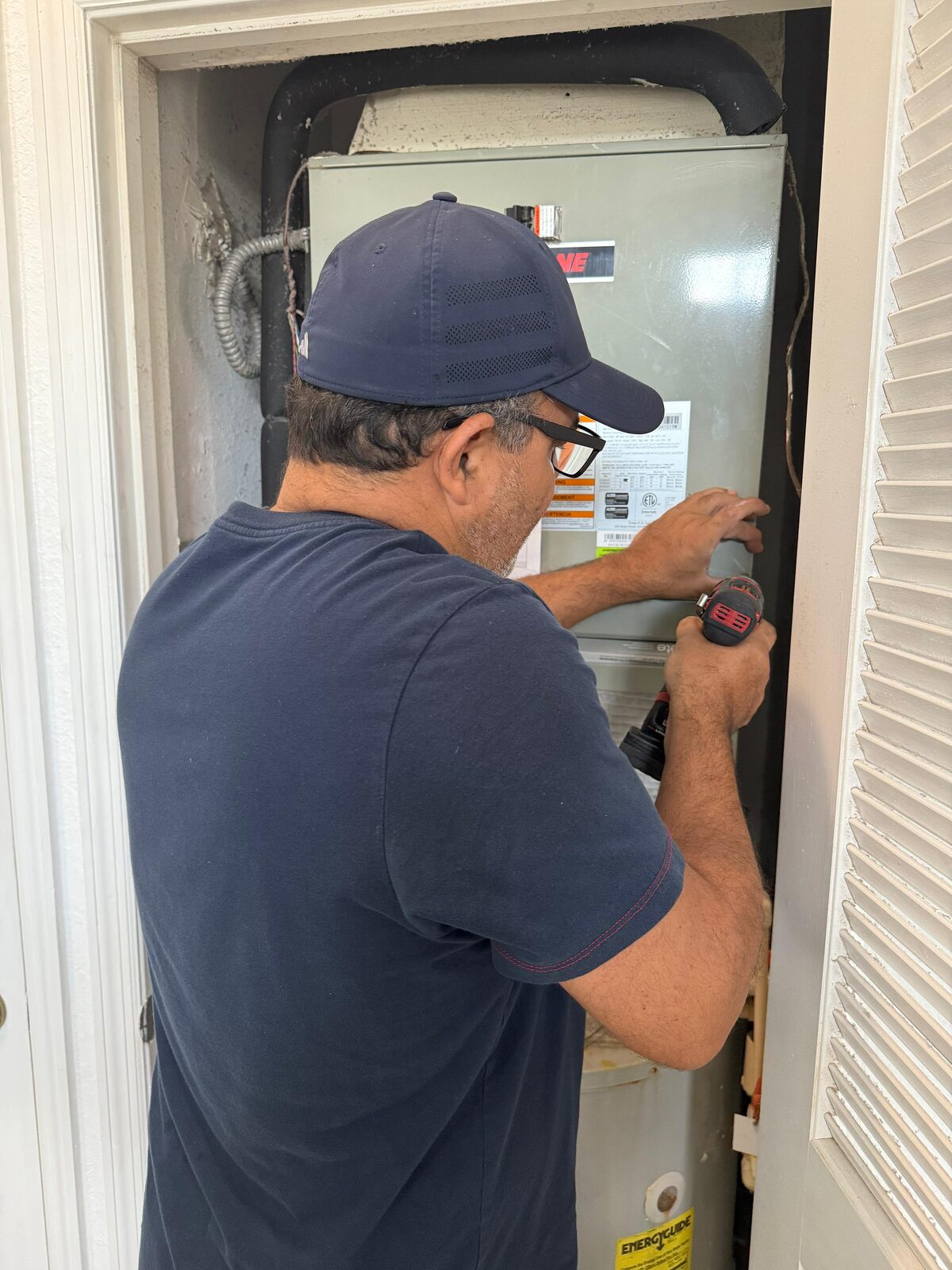 Go2 Workers pro servicing an AC air handler unit inside a home closet in Central Florida